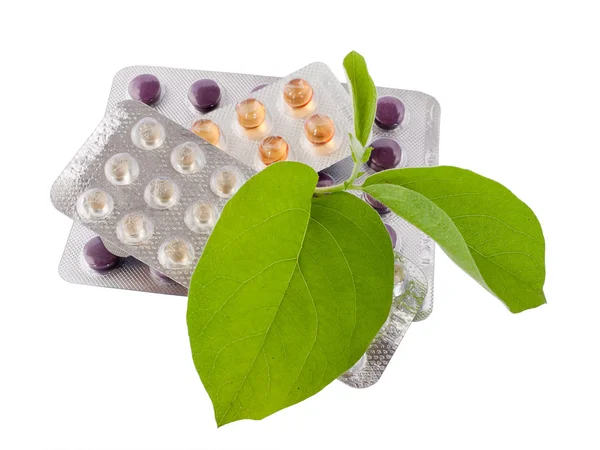 Bundle of pills with green leaves. — Stock Photo, Image
