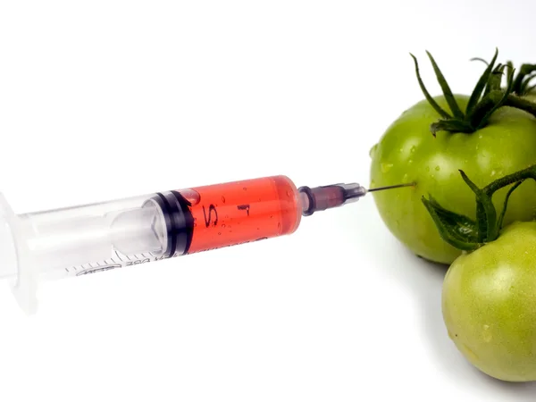 Filed syringe and green tomatoes — Stock Photo, Image
