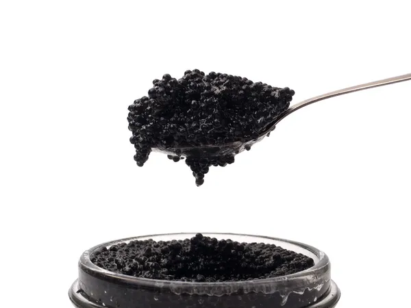 Caviale nero in cucchiaio sopra il barattolo — Foto Stock