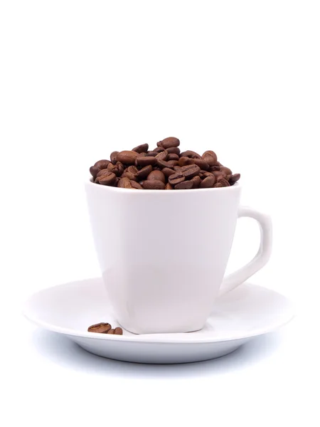 Kopp och fat med kaffebönor Royaltyfria Stockfoton