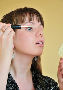 Applying make up - white mascara clipart