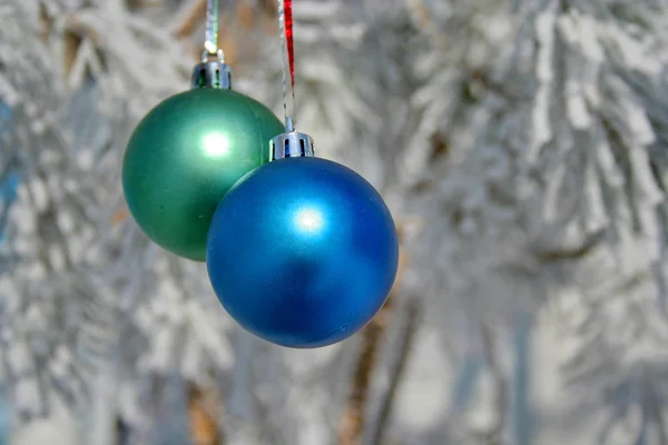 Два цветных шара на заснеженном дереве — стоковое фото