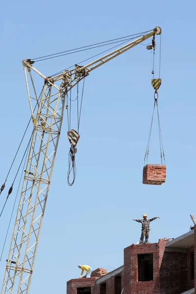 Lifting-crane lifts a bricks — Stock Photo, Image