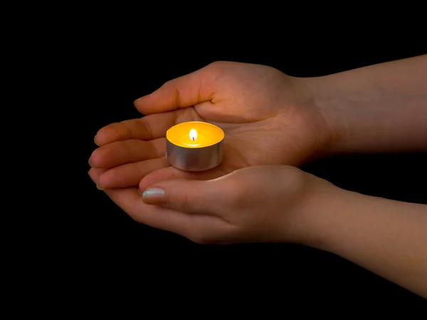 Hände und brennende Kerze — Stockfoto
