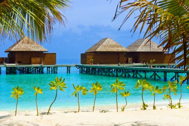 Water bungalows on a tropical island clipart