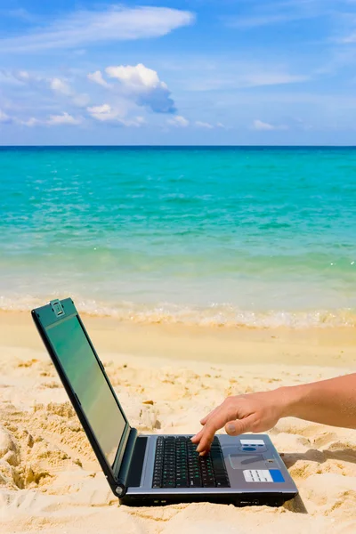Számítógép és a kezét a strandon — Stock Fotó