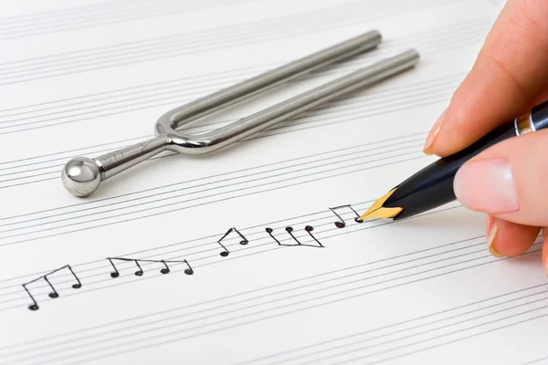 Hand med penna och musik ark — Stockfoto