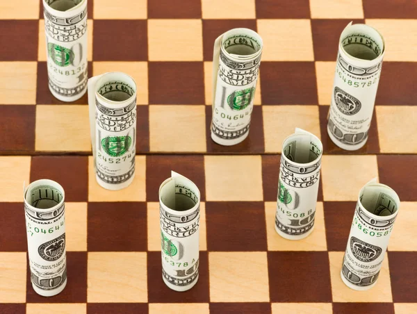 Dinero en tablero de ajedrez —  Fotos de Stock