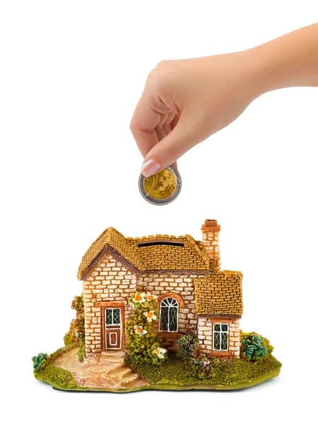 Hand met munt en huis bank — Stockfoto