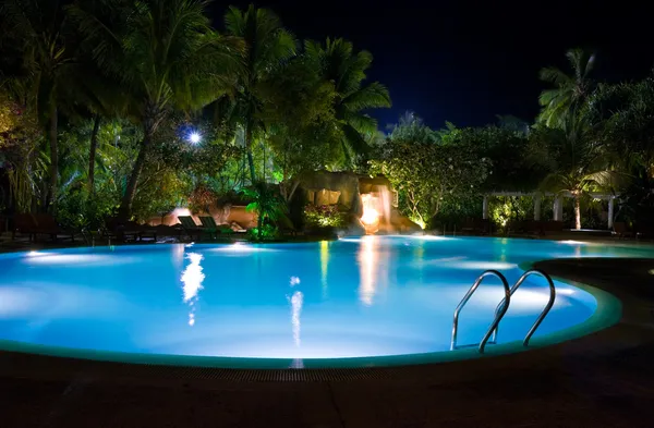 Zwembad en waterval in de nacht — Stockfoto