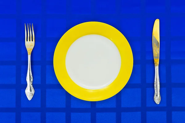 Placa, faca e garfo na toalha de mesa — Fotografia de Stock