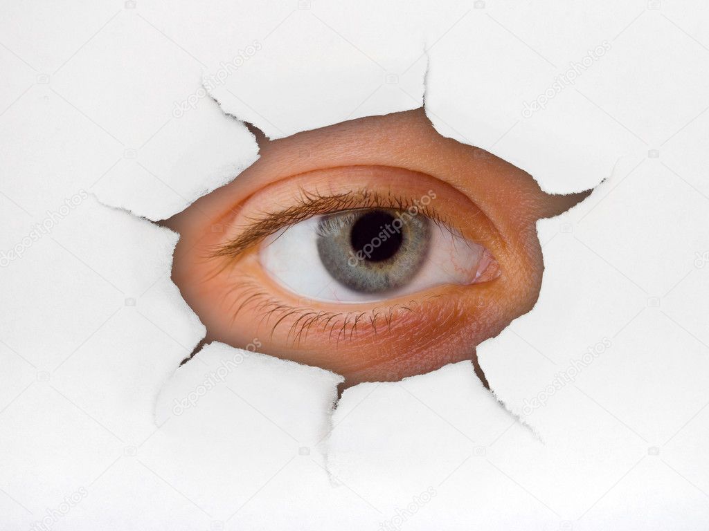 Eye looking through hole on paper