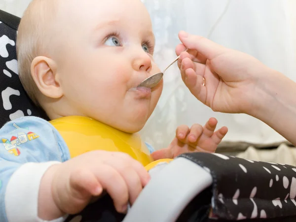 Bir kaşık gelen çocuk yiyor — Stok fotoğraf