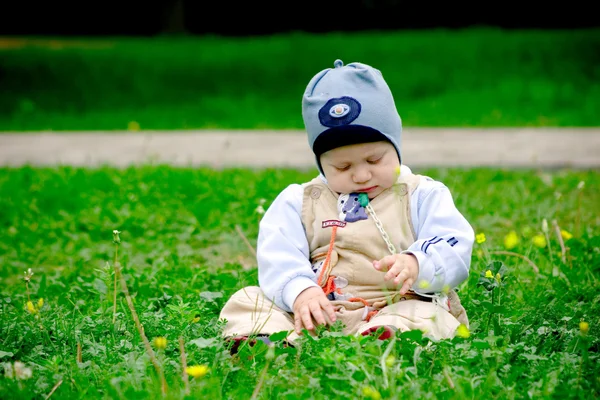 Bebê menino sentado amoung flores — Fotografia de Stock
