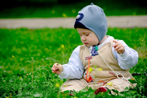 Малыш сидит в зеленой траве — стоковое фото