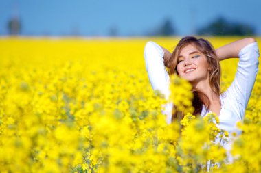 Girl relaxing in field of flowers clipart