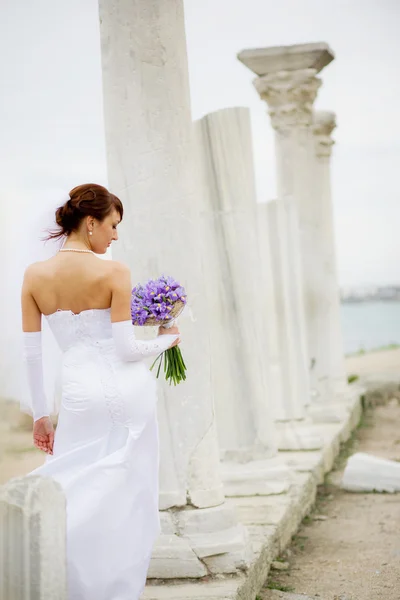 Bride among ancient columns — Stock fotografie