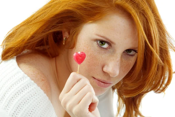 Menina sexy com cabelo vermelho segurando um coração — Fotografia de Stock