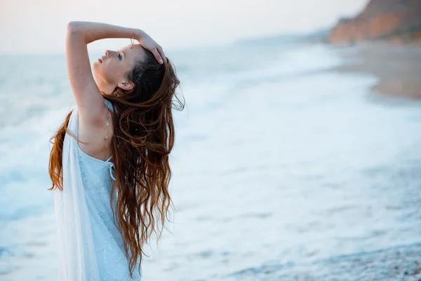 Beautiful model on beach at sunset — Stock Photo, Image