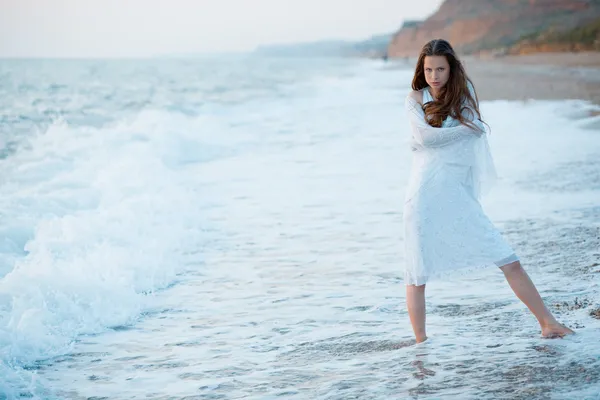 Woman in sea waves at sunset — Stock Photo, Image