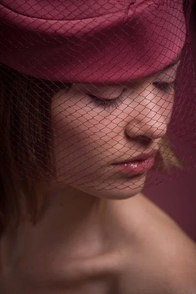 Женщина в розовой шляпе с вуалью — стоковое фото