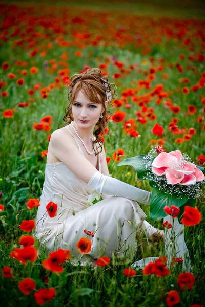 Girl sitting among poppies — Stock Photo, Image