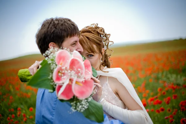 对年轻夫妇在罂粟的字段 — 图库照片
