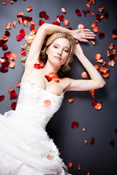 Sposa sdraiata tra petali di rosa — Foto Stock