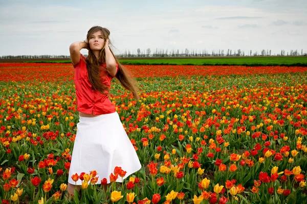 Mooie vrouw in tulpenveld — Stockfoto