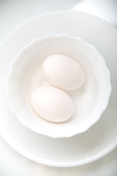 Two fresh eggs in snowy white dish
