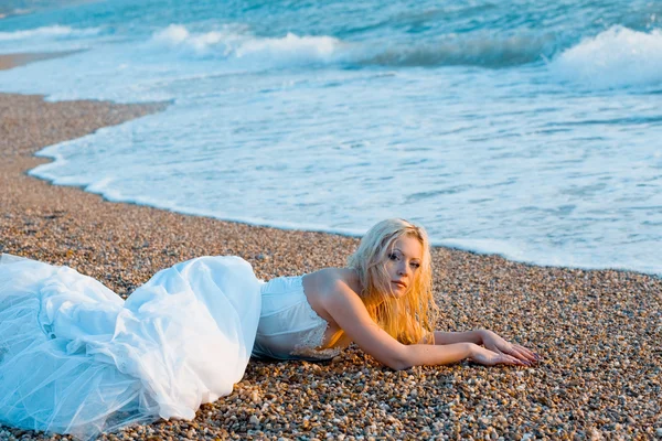 Noiva deitada na costa do mar Fotografia De Stock