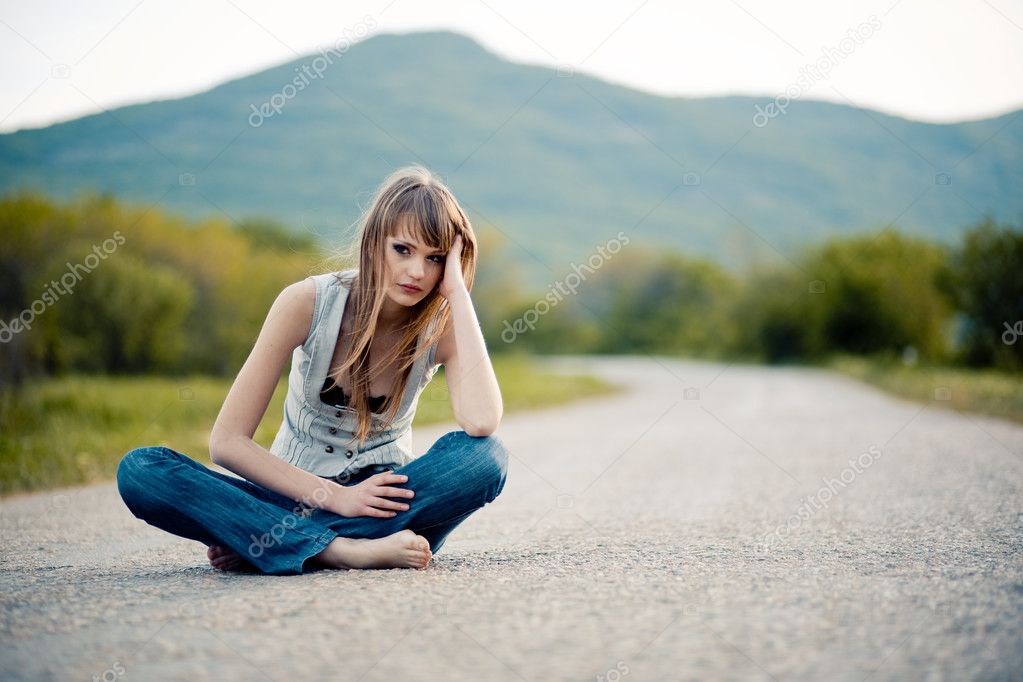 Teenager girl sitting on road