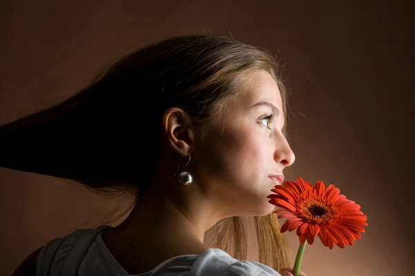 Молодая женщина с красным цветком — стоковое фото