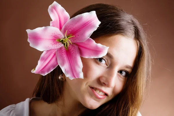 Молода жінка позує з рожевою лілією — стокове фото