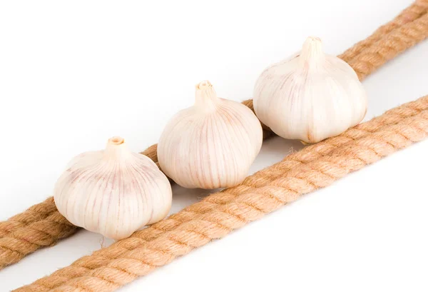 Three bulbs of garlic near the rope — Stock Photo, Image