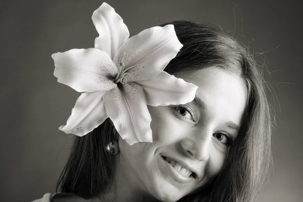 Ung kvinna poserar med en Lilja — Stockfoto