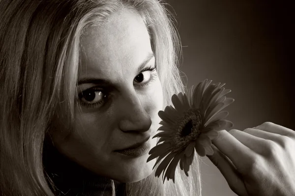 Blondin poserar med en blomma — Stockfoto