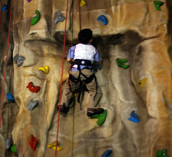 Kleiner Junge klettert eine Wand hoch — Stockfoto