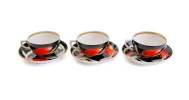 Row of three black tea cups with saucers clipart