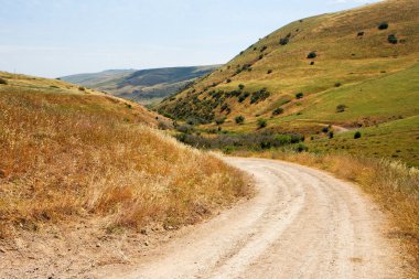 Sarı tepeler arasında kırsal yol