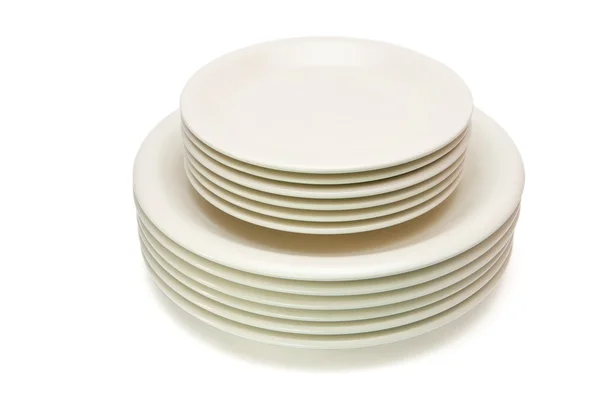 Stack of plain beige plates and saucers — Stock Photo, Image