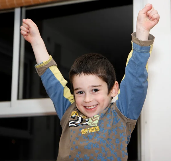 Milý chlapeček zvedá ruce v v-sign — Stock fotografie
