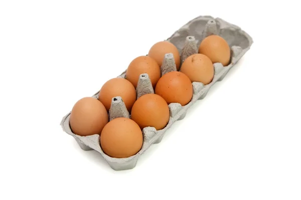 Nove ovos marrons em uma caixa de papel isolada — Fotografia de Stock