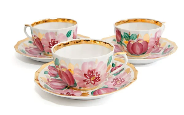 3 чашки чая с блюдцами, раскрашенные цветами — стоковое фото