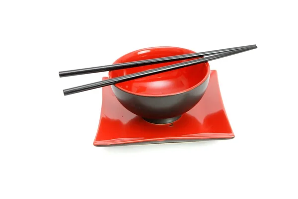 Eetstokjes op rode en zwarte bowl — Stockfoto