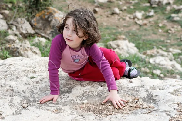 Küçük kız kayanın üzerinde yer alır. — Stok fotoğraf