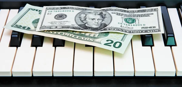 Twee dollarbiljetten op orgel toetsenbord — Stockfoto