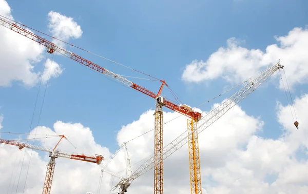 Crossing lifting cranes over cloudy sky — Stock Photo, Image