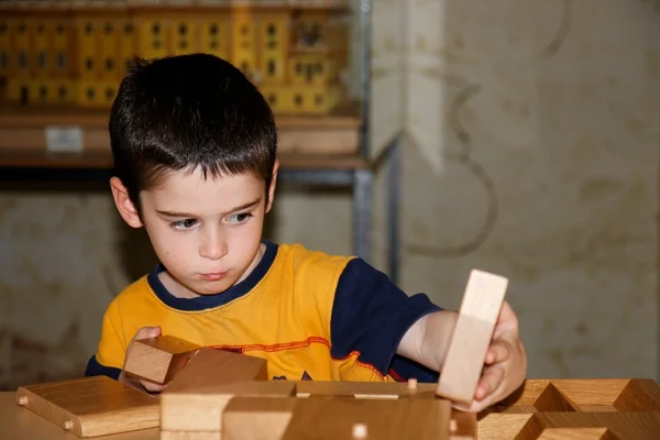 Милый мальчик играет с деревянными кирпичами — стоковое фото