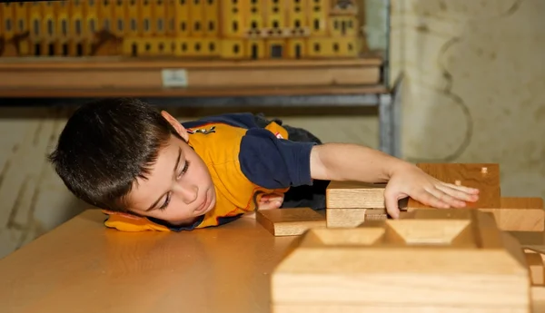 Cute little boy plays with wooden bricks — Stock Photo, Image